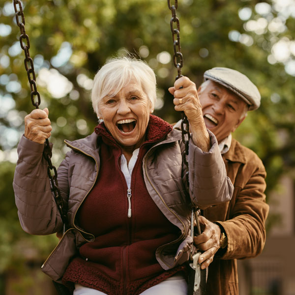 senior couple playing on swings